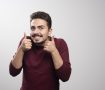 A young brunette man showing thumbs up . High quality photo